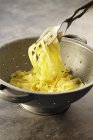 Linguine pasta in colander — Stock Photo