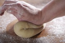 Closeup cropped view of hand kneading dough — Stock Photo