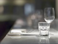 Closeup view of a place setting with glasses, cutlery and a napkin — Stock Photo