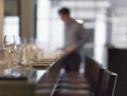 Fila di sedie al tavolo del ristorante e persona offuscata sullo sfondo — Foto stock