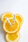 Fette arancioni con cannucce — Foto stock