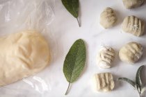 Vue de dessus des feuilles fraîches de gnocchi, beurre et sauge — Photo de stock