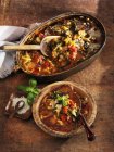 Sopa de verduras toscana con col rizada verde, tomates y frijoles en platos sobre superficie de madera - foto de stock