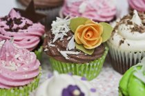 Various cupcakes with sugar flowers — Stock Photo