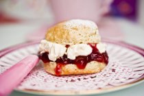 Scone with cream and strawberry jam — Stock Photo