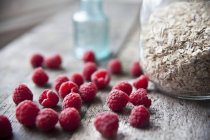 Fresh raspberries with jar of oats — Stock Photo