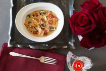 Top view of lobster soup with mushrooms and roses bouquet — Stock Photo