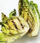 Grilled lettuces over white surface — Stock Photo