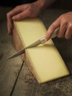 Gruyere cheese being sliced — Stock Photo