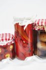 Jars of pickled peppers, chillis and onions as homemade Christmas presents on white background — Stock Photo