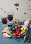 Un piatto di antipasto con foglie e verdure ripiene, pane bianco e vino rosso — Foto stock