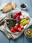 An appetiser platter with stuffed vine leaves and vegetables over wooden surface — Stock Photo