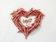 Um coração feito de feijão borlotti sobre a superfície branca — Fotografia de Stock