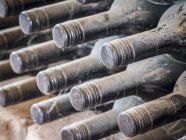 Vista close-up de garrafas de vinho pescoços em teia de aranha e poeira — Fotografia de Stock