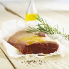 Raw beef with olive oil and rosemary — Stock Photo