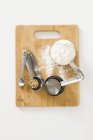 Top view of various measuring spoons on a chopping board — Stock Photo