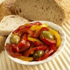 Red and yellow peppers with green olives — Stock Photo