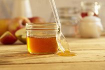 Jar of honey with spoon — Stock Photo