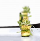 Courgette rolls with fresh cress over white surface — Stock Photo