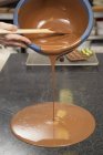 Hand gießt geschmolzene Schokolade — Stockfoto