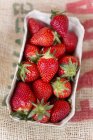 Strawberries in paper punnet — Stock Photo