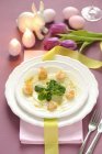 Kohlrabi carpaccio with prawns and lamb's lettuce for Easter in white plate over towel — Stock Photo