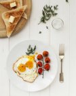 Fried egg with tomatoes on plate — Stock Photo