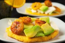 Arepas with avocado on plates — Stock Photo