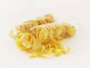 Dried tagliatelle pasta in bag — Stock Photo
