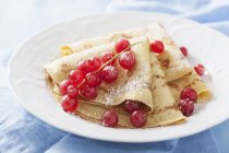 Pancakes with redcurrants and icing sugar — Stock Photo