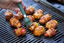 Hand cooking Stuffed peppers wrapped in bacon — Stock Photo