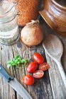 Vista elevata di una disposizione di lenticchie, erbe e pomodori — Foto stock