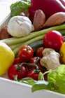 An arrangement of various types of vegetables in a white wooden crate — Stock Photo