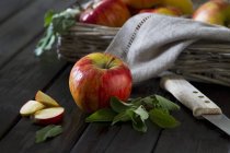Manzanas enteras y en rodajas con hojas - foto de stock