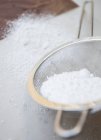 Icing sugar in strainer — Stock Photo