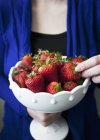 Frau hält Erdbeeren in Schüssel — Stockfoto