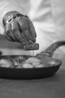 Vue rapprochée d'un chef préparant un plat de poisson — Photo de stock