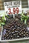 Elevated view of black olives with price tag — Stock Photo