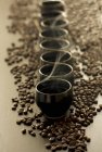 Closeup view of steaming cups of coffee on coffee beans — Stock Photo