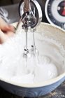 Beating Meringue with vintage hand whisk — Stock Photo