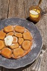 Tarte tatin con una base di patate e mandorle su piatto su superficie di legno — Foto stock