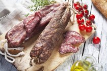 Spanish smoked sausages on wooden board — Stock Photo