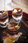 Vermouth with ice cubes and olive skewers in glasses — Stock Photo