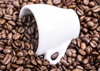 Taza de café espresso en granos de café - foto de stock