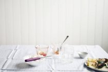 Gli occhiali usati e un piatto con il cibo rimangono su un tavolo — Foto stock