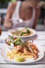 Prawns with fries and lettuce salad — Stock Photo