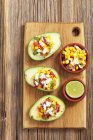Gefüllte Avocados mit Mais-Salsa auf Holztisch über Tisch — Stockfoto