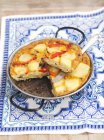 Tortilla de batata com pimenta vermelha sobre toalha branca e azul colorida — Fotografia de Stock