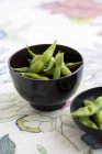Fresh soya beans in black bowl — Stock Photo