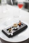 Elevated view of goose Creme brulee with appetizers and spoon on wooden dish — Stock Photo